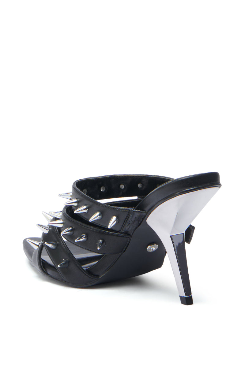 The AZALEA WANG PEREGRINE BLACK STUD AND SPIKE MULE SANDAL features multiple faux leather straps with large silver spikes and a shiny metallic stiletto heel, shown from the back on a white background. 5