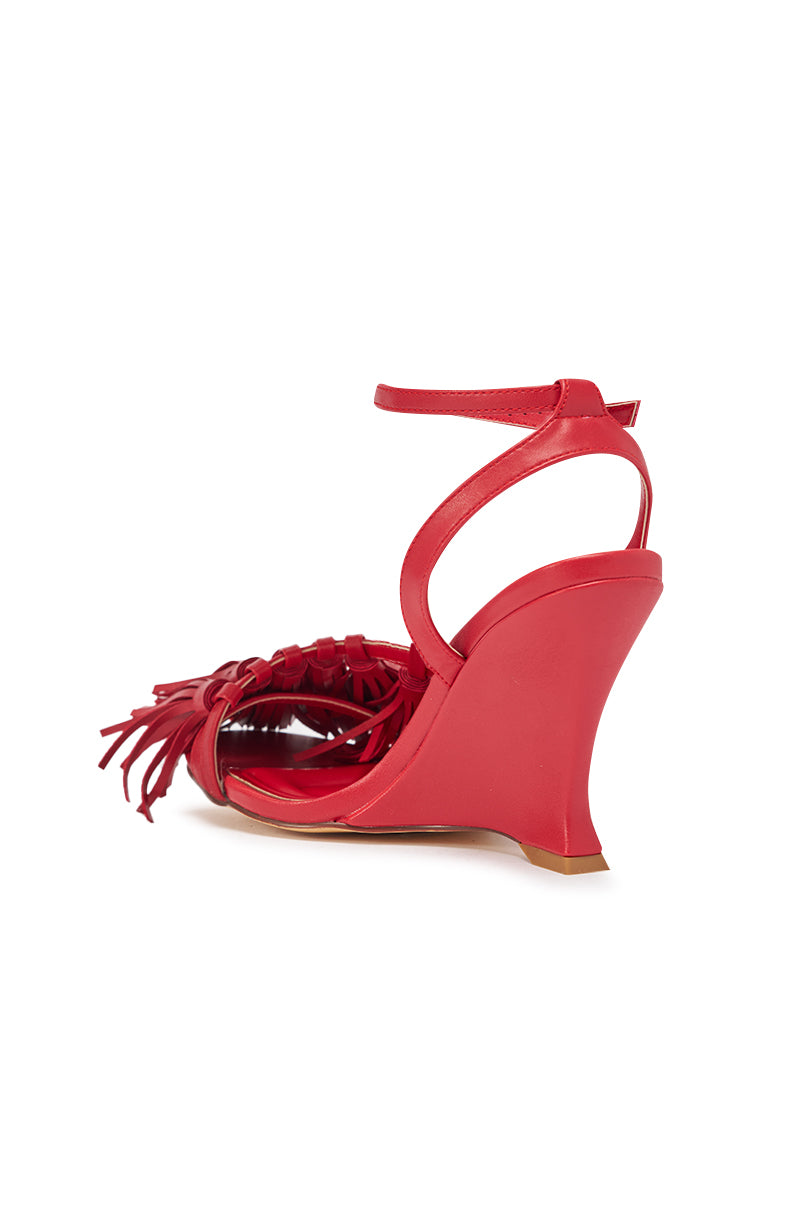 The AZALEA WANG PHRIXOS RED WEDGE FRINGE PU SANDAL features a comfortable wedge heel, ankle strap, open toe, and front fringe detail, shown from the back against a white background. 5