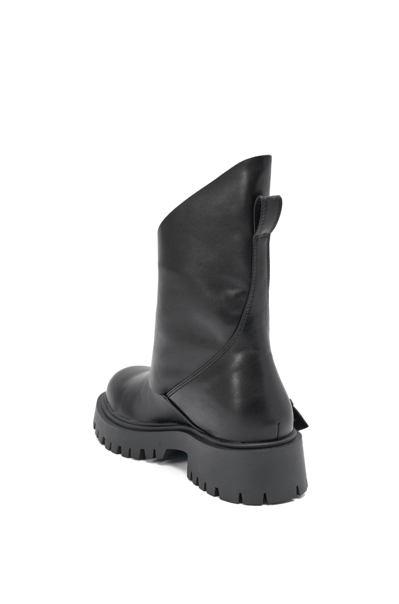 The AZALEA WANG PHRIXUS Black Chunky Short Shaft PU Boot is a black faux leather mid-calf boot with a chunky ridged sole, pull tab, and smooth seamless side stitching, shown from the back at an angle.