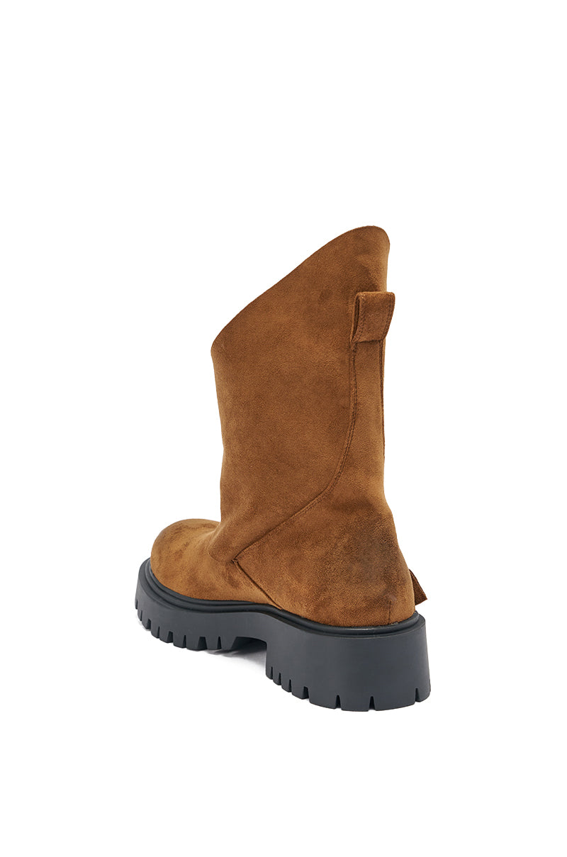 The AZALEA WANG PHRIXUS Brown Chunky Short Shaft Faux Suede Boot features a brown faux suede finish, a chunky platform lug sole, pull tab on the heel, and a slightly asymmetrical, slouched upper viewed from the back.