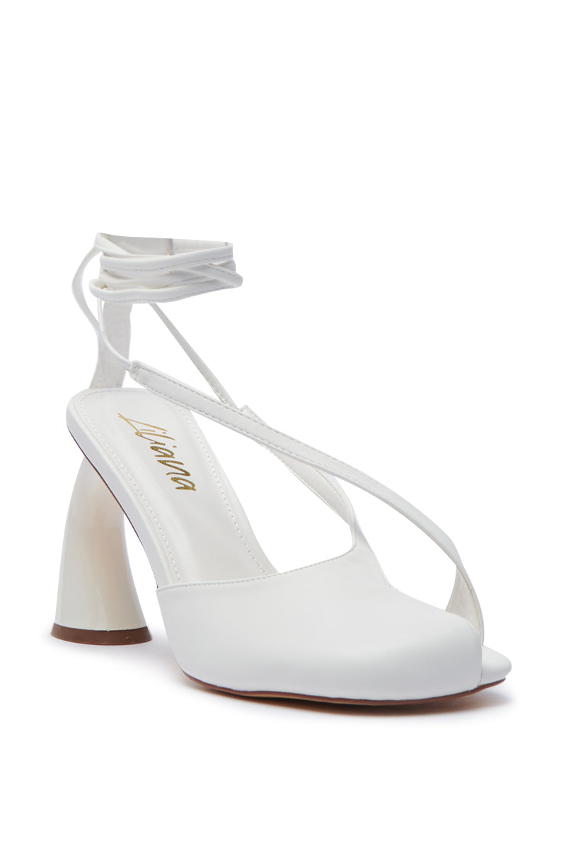 Introducing the PIRATE WHITE PEEP TOE PUMP, a sleek white high-heeled sandal that boasts a chic crisscross design complemented by an ankle strap, perfectly aligning with the Balletcore Trend. With its chunky heel and elegant, minimalist style, this shoe blends style and comfort effortlessly. The brand name is subtly displayed on the insole for an added touch of sophistication.