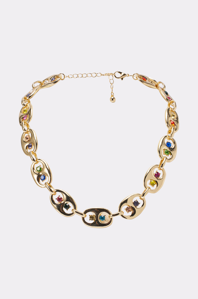 The A GOOD TIME NECKLACE is a rhinestone gold necklace with oval links, each centered with vibrant gemstones in green, blue, red, and purple. This festival-ready piece features an adjustable clasp and showcases rainbow jewel tones. 2