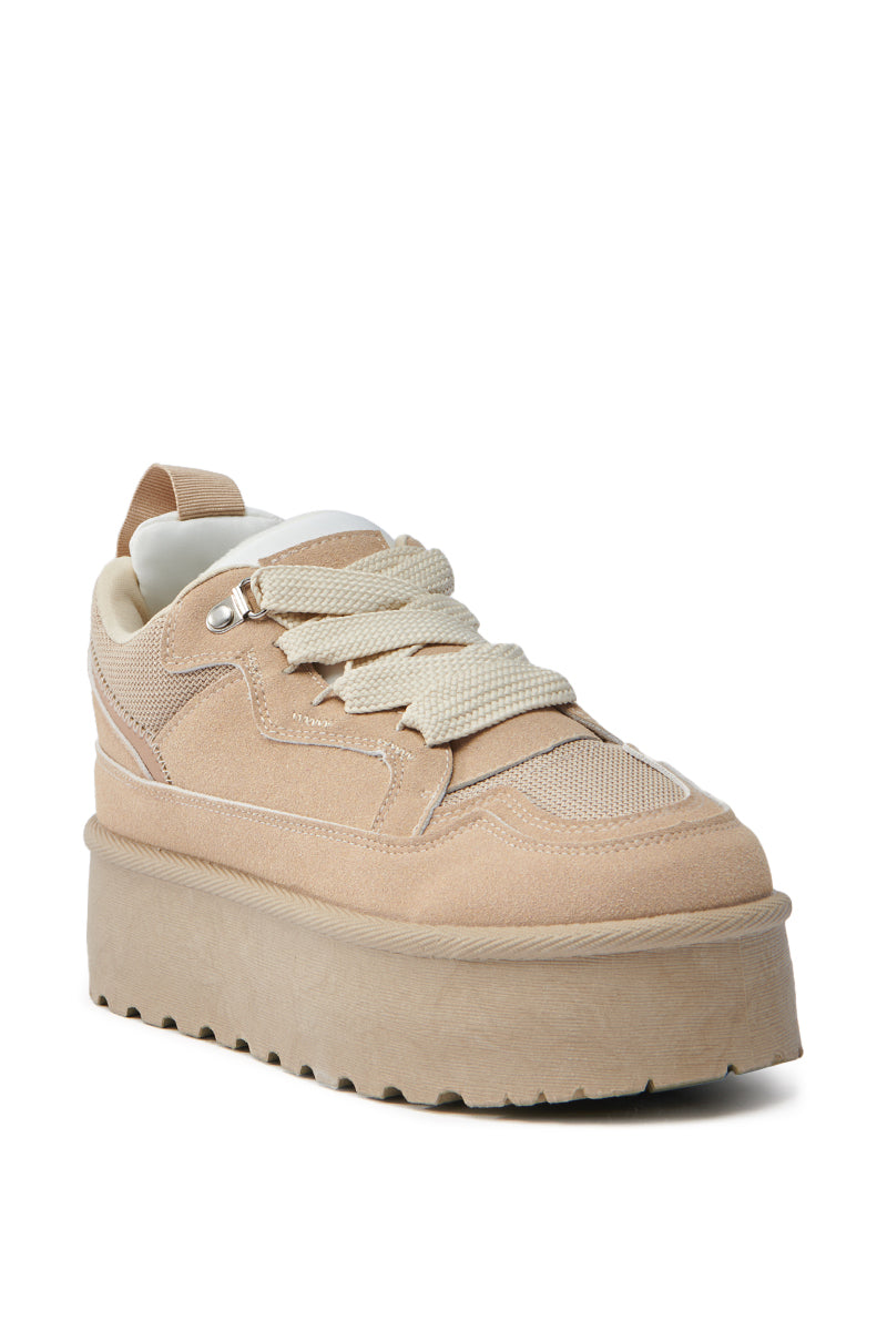 The POPULARITY SAND FLATFORM SNEAKER is a beige flatform shoe with an almond toe, thick sole, wide laces, and features a suede textile upper with mesh accents. It includes metal eyelets and a heel pull tab for added detail. 4