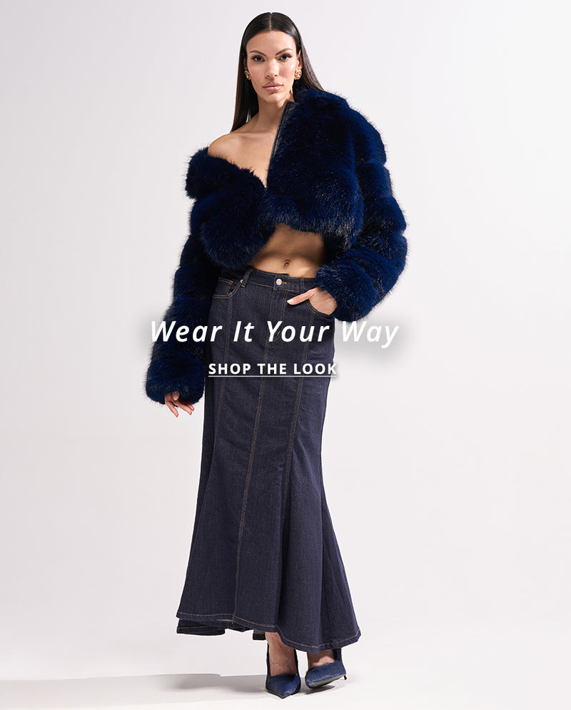 Woman wearing a blue fur coat and black denim skirt on a white background with text 'Wear It Your Way' and 'Shop The Look'.