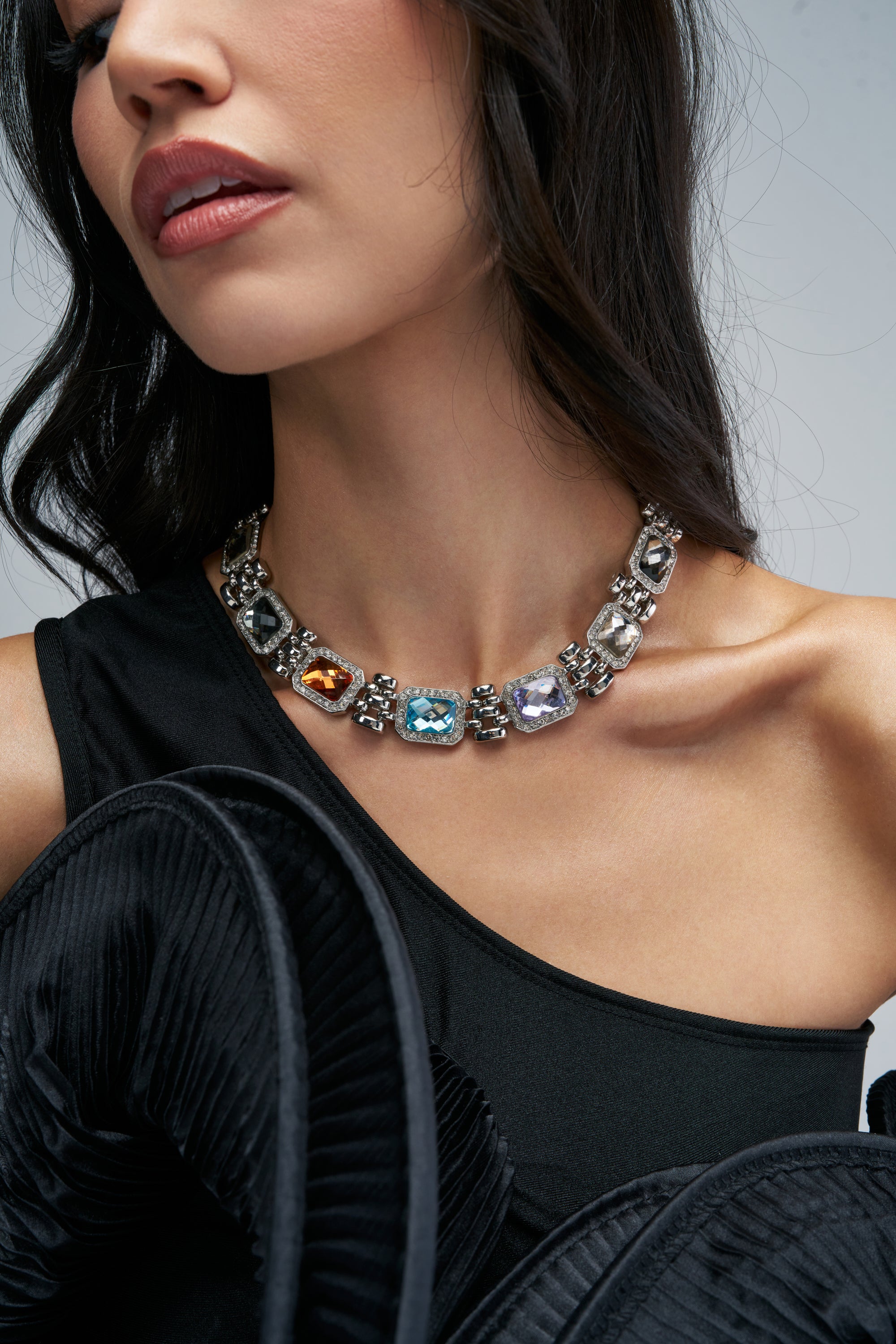 SILVER DIVA COLLAR NECKLACE featuring a series of silver rectangular links with alternating amber, blue, clear, and violet gemstones.