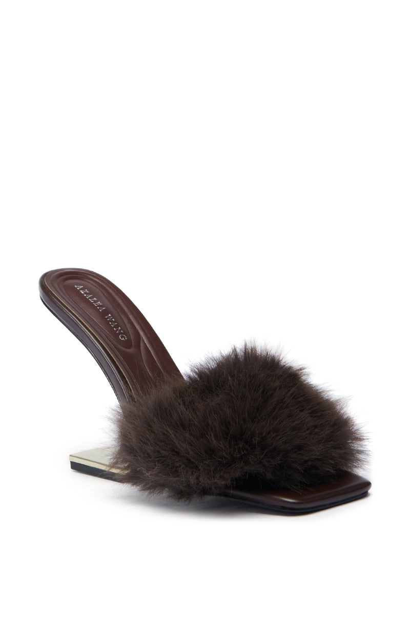 The AZALEA WANG PUPON BROWN FUR SANDAL WITH WEDGE HEEL is a single high-heeled sandal featuring a square toe and brown faux fur adorning the front strap. This faux leather sandal showcases a sleek, glossy brown finish with a fur wedge heel, presented against a plain white background.