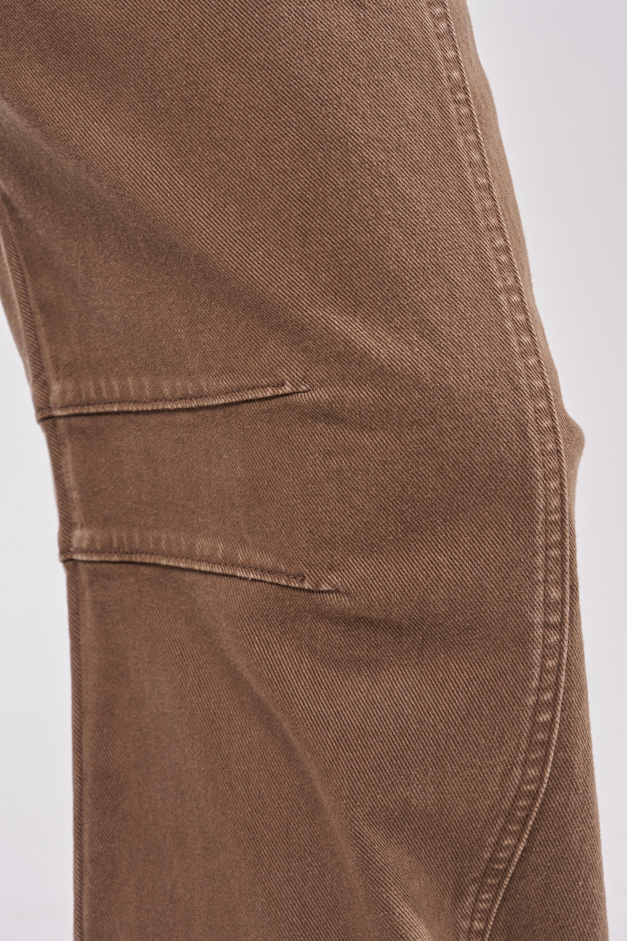 Close-up of the side of FEELING GREAT BARREL DENIM, highlighting a visible seam and horizontal pocket detail against a plain background. 7