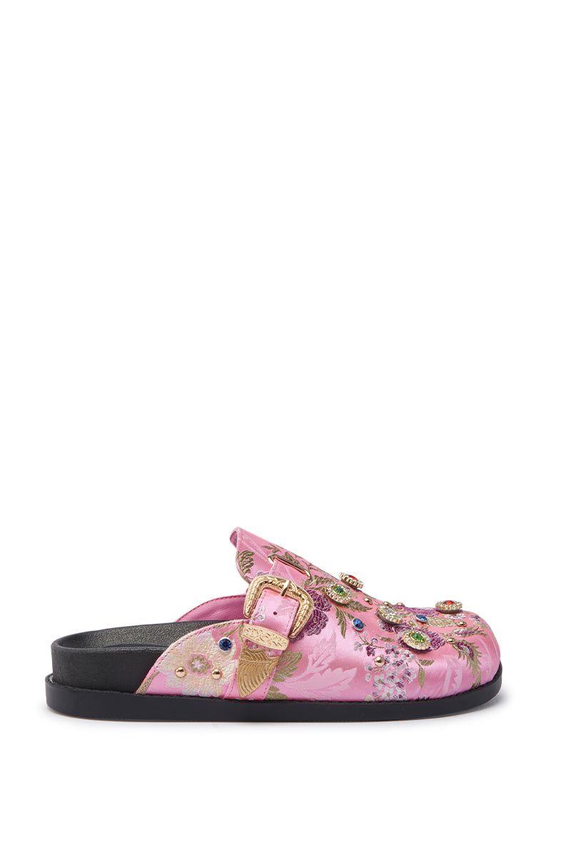 The AZALEA WANG QUINBY BROCADE CLOG IN PINK is a pink slip-on mule featuring a black sole, adjustable buckled strap, and detailed floral brocade embroidery with gemstone accents on the upper.