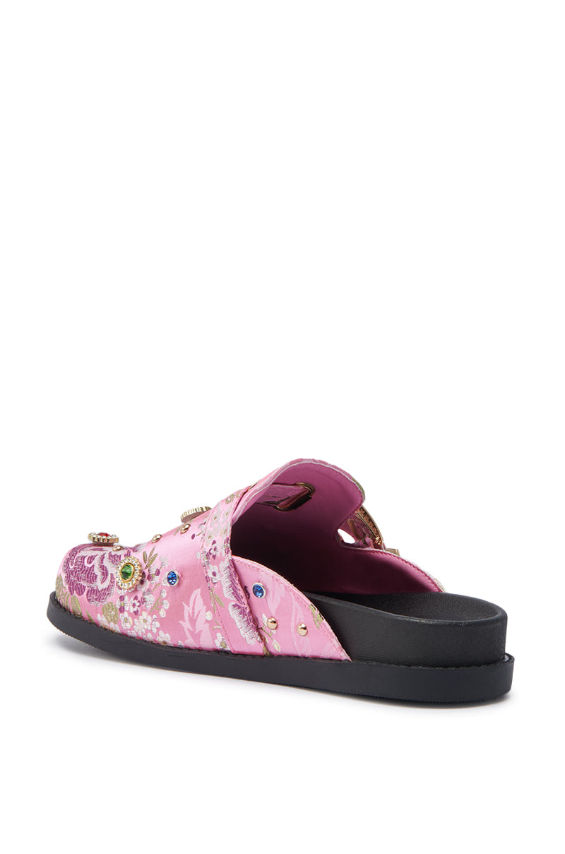 The AZALEA WANG QUINBY BROCADE CLOG IN PINK is a pink slip-on sandal with a flat black sole, floral brocade embroidery, gemstone accents, and a decorative top strap. The sandal is shown from the back.