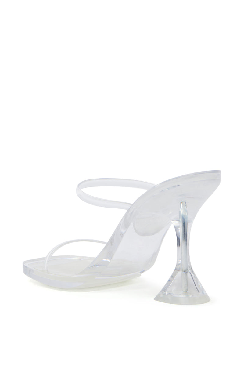 The AKIRA QUIRON CLEAR SANDAL is a minimalist clear high-heeled sandal with an open square toe, transparent strap, and flared stiletto heel. It is slightly angled to highlight the heel and sole.