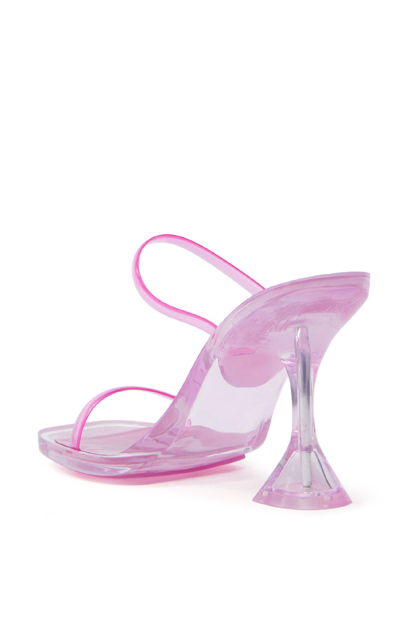 The AKIRA QUIRON PINK SANDAL boasts a PVC upper and clear straps, featuring a unique flared heel. Its transparent design provides a modern, trendy look for fashion-forward footwear enthusiasts.