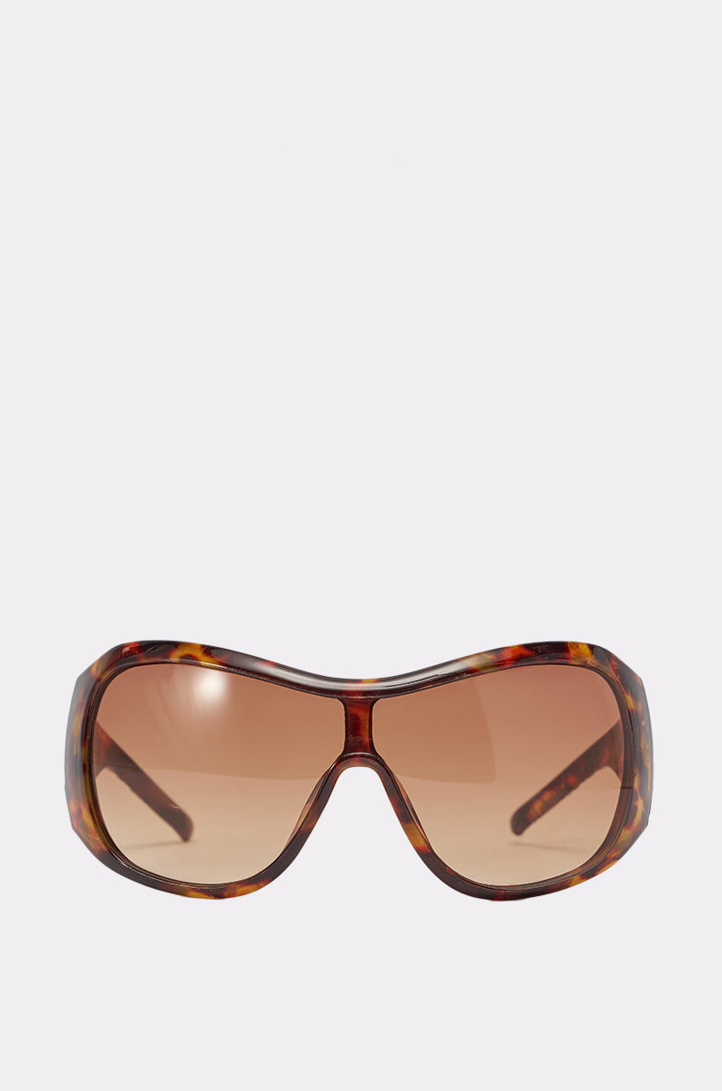 TORTALLY SUNGLASSES: Brown oversized shield sunglasses featuring a tortoise shell frame and gradient-tinted lenses, shown on a plain white background. 0