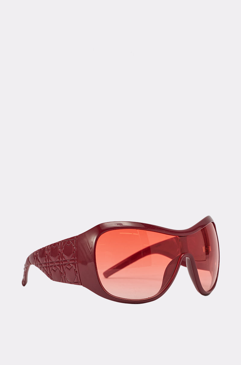 WITH LUV SUNGLASSES: Bold shield sunglasses with wide, textured arms and large tinted red lenses in a striking wraparound style, displayed on a light background. 2