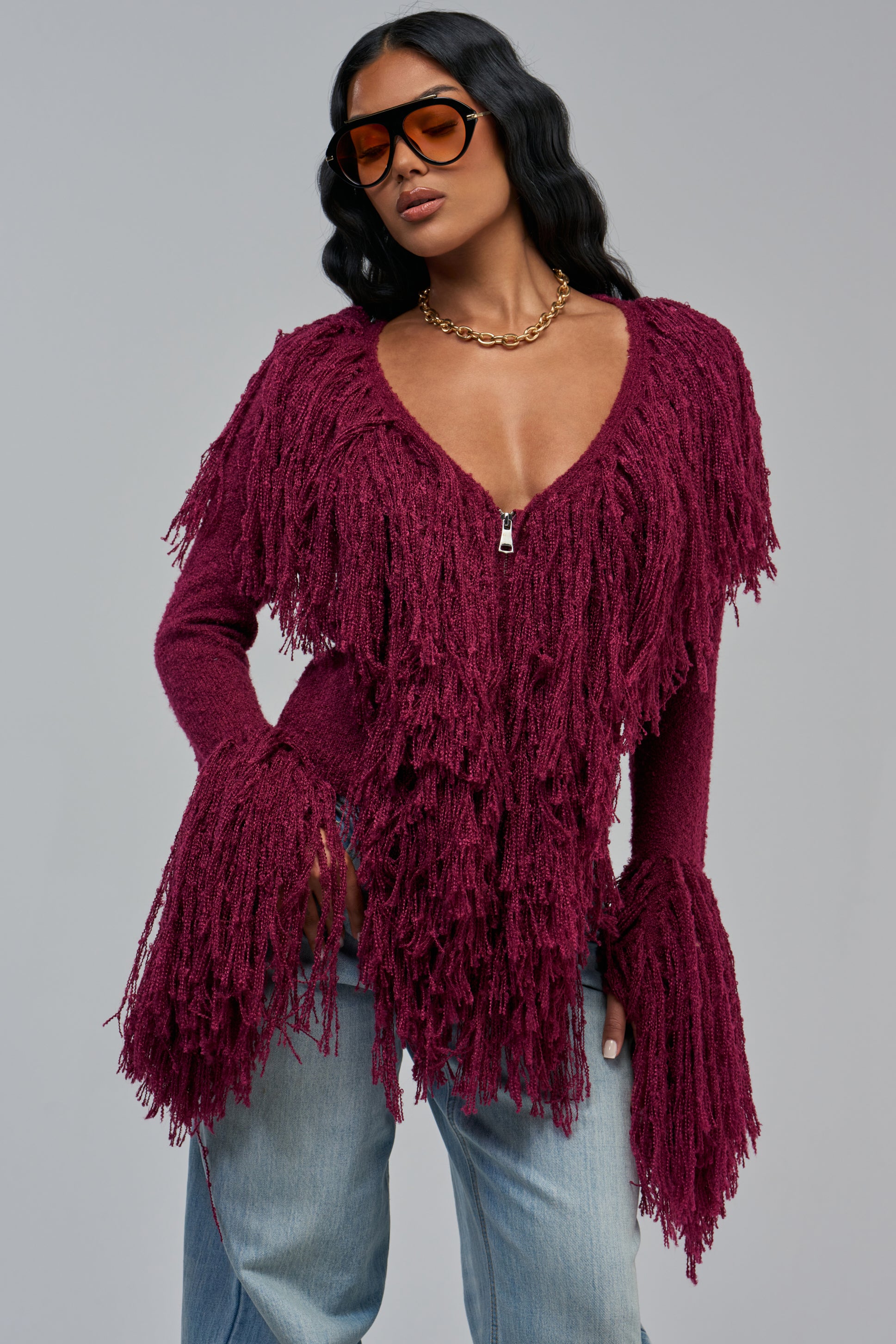 AT YOUR BEST FRINGE CARDIGAN IN PLUM, a cropped V-neck cardigan featuring a zipper closure and dramatic fringe detailing on the bodice and wide sleeves.