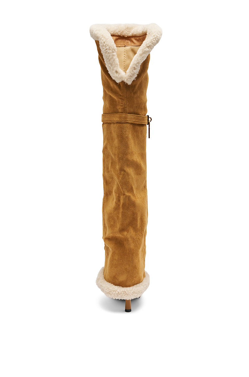 The AZALEA WANG RACHANA Tan Sherpa Stiletto Boot is a tall, tan faux suede boot with a white sherpa lining, pointed toe, and high stiletto heel, displayed from the front against a white background.