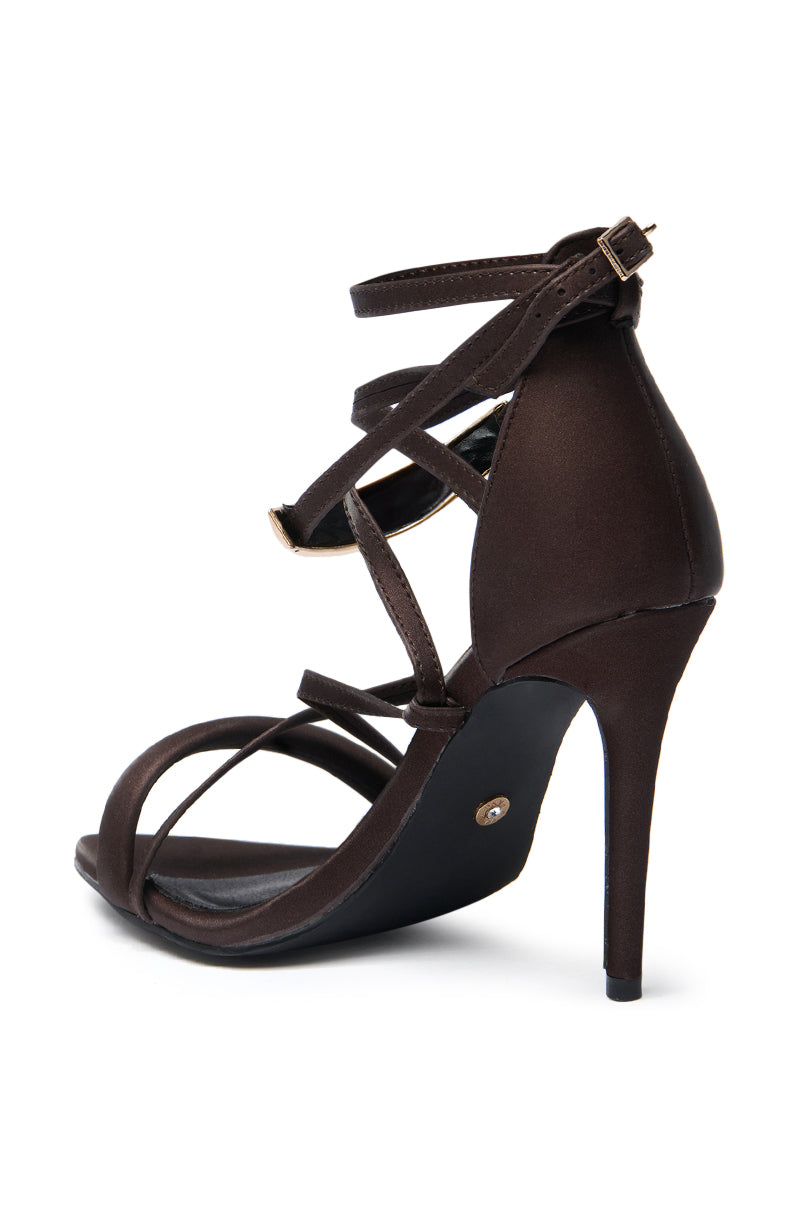 The AZALEA WANG RADHA Chocolate Metal Embellished Sandal features multiple thin straps, an ankle buckle closure, and a chic stiletto heel, displayed side view on a white background. 6
