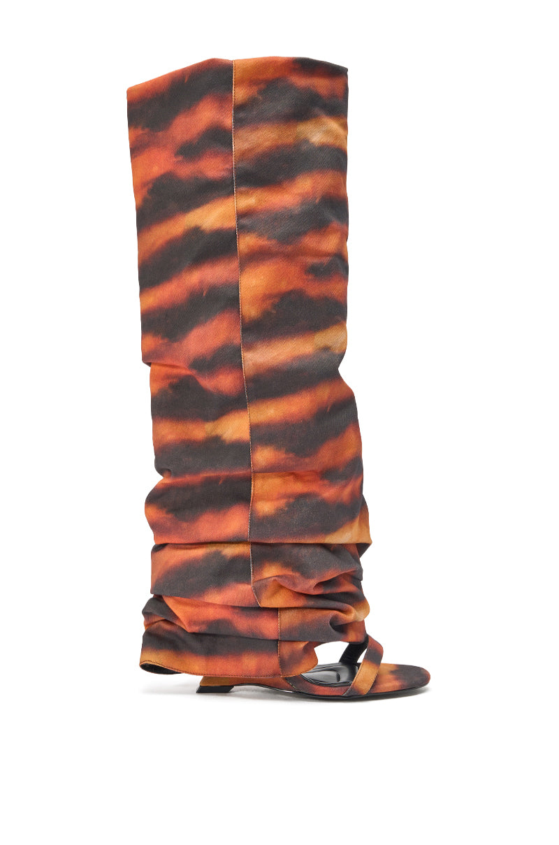The AZALEA WANG RADLEY TIGER PRINT SLOUCHY WEDGE BOOT is a tall, open-toe Y2K boot with an orange and black tiger print, a slouchy fit, high over-the-knee shaft, and low wedge heel for bold statement style. 2