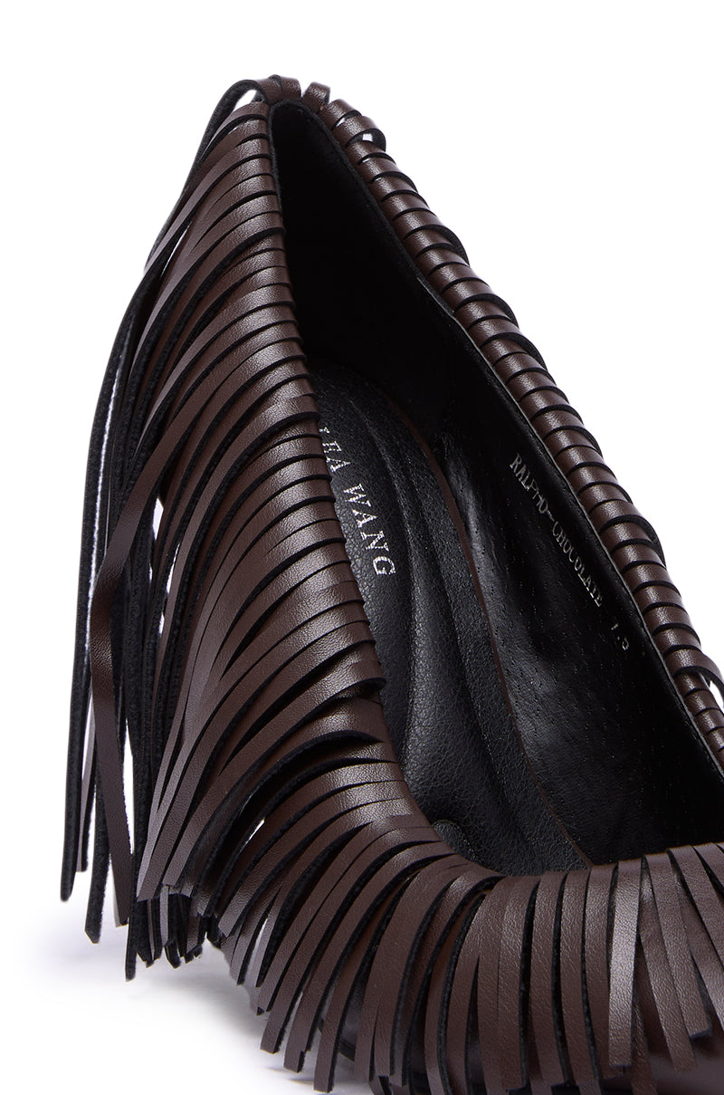 Close-up of the AZALEA WANG RALPH CHOCOLATE FRINGE CLASSIC PUMP, highlighting multiple thin leather fringe strips along the edge, visible stitching, and part of the brand label on the insole.