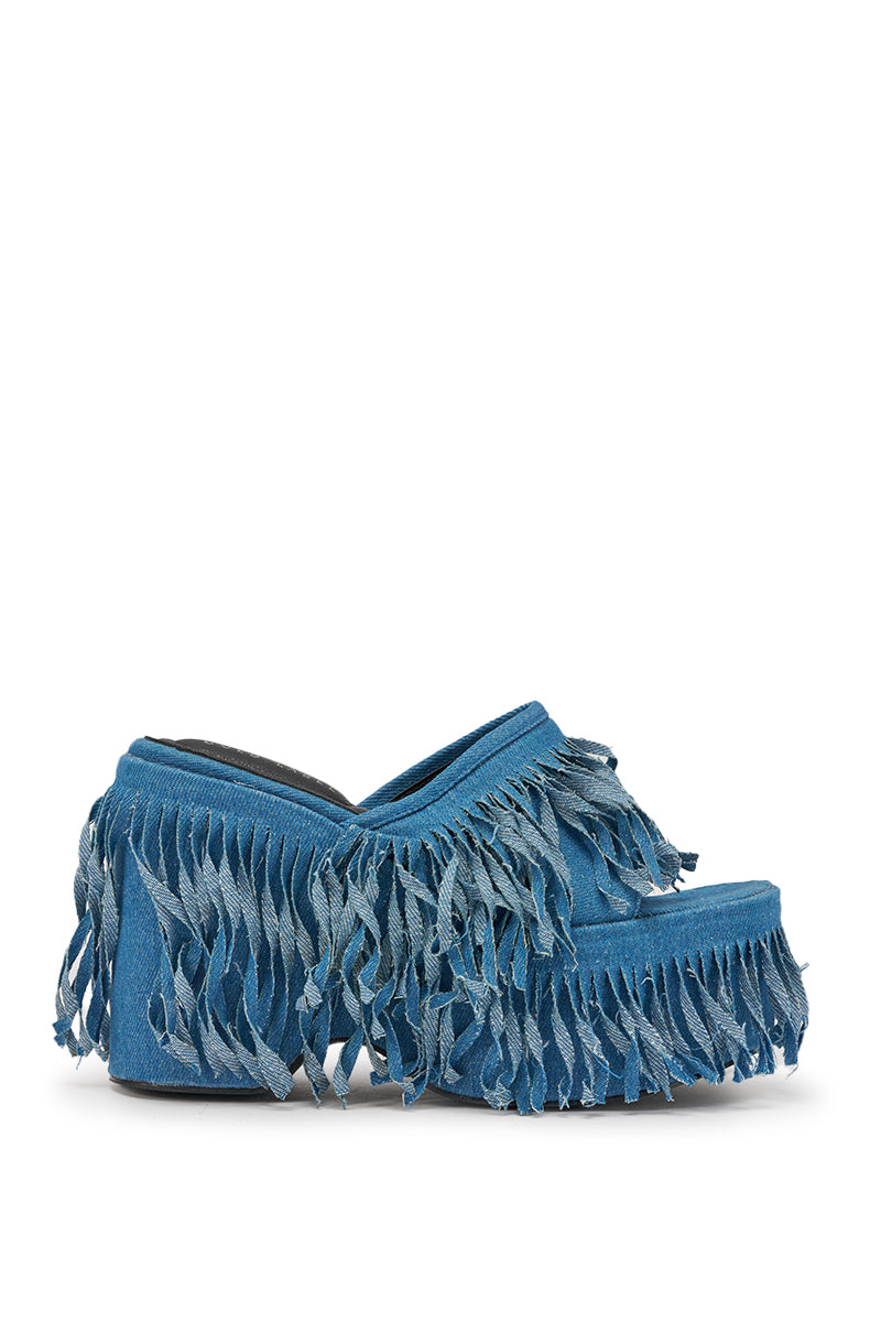 The AKIRA GOLD RAMESHA DENIM FRINGE PLATFORM SANDAL features blue denim, layered fringe on the upper, sides, and sole, a chunky heel, open back, and playful textured style. 3
