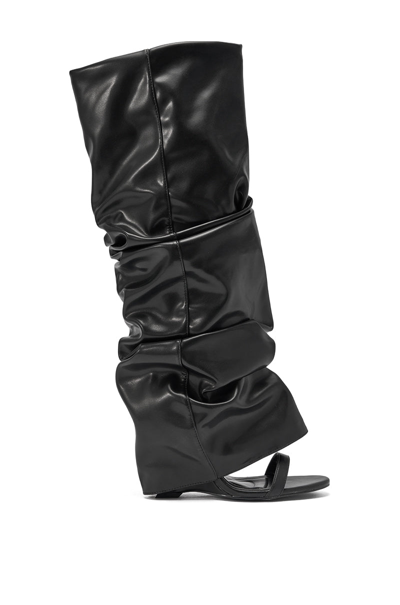 The AZALEA WANG RAYLAN BLACK GLADIATOR SANDAL is a single black, slouchy knee-high sandal made of shiny faux leather with a flat sole and open toe design. 3