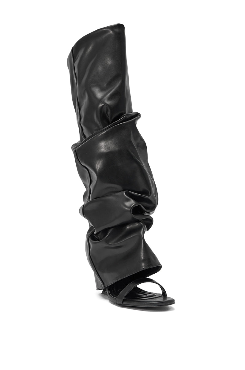 The AZALEA WANG RAYLAN BLACK GLADIATOR SANDAL is a tall, black, slouchy faux leather boot with an open toe and heel, featuring a loose wrinkled shaft and flat sole. 4