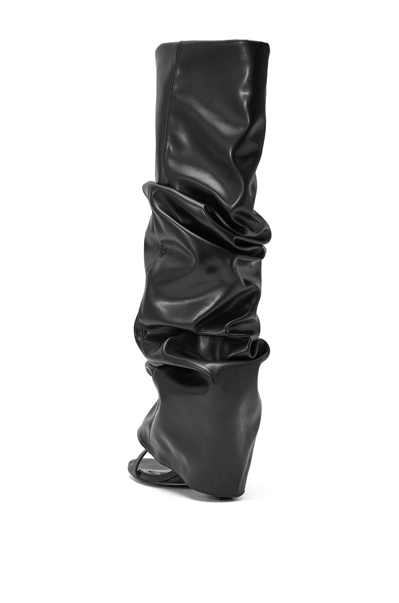 The AZALEA WANG Raylan Black Gladiator Sandal is shown from the rear, featuring a knee-high, slouchy ruched design with a high heel in shiny faux leather against a white background. 5