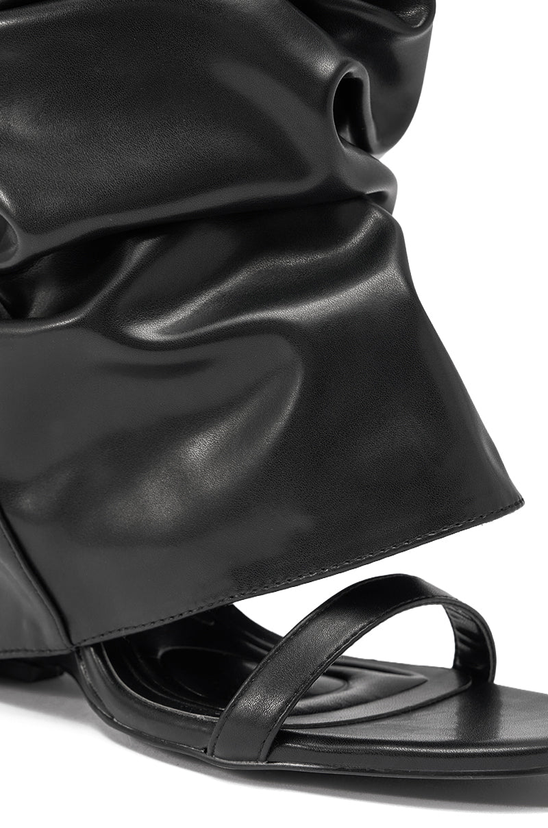 Close-up of the AZALEA WANG RAYLAN BLACK GLADIATOR SANDAL, featuring a black square toe, single thin front strap, and an oversized slouchy faux leather upper that covers the ankle. 6