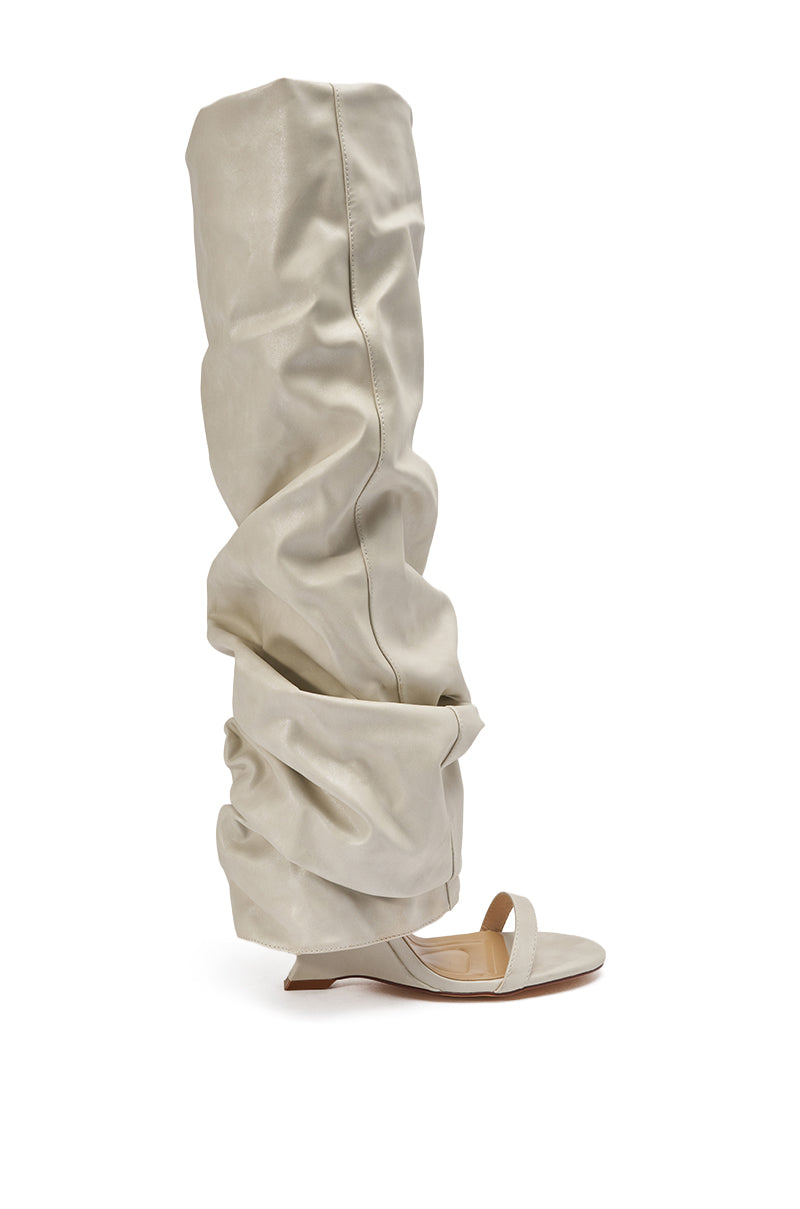 The AZALEA WANG RAYLAN BONE GLADIATOR SANDAL is a light gray, open-toe sandal with an exaggerated slouchy ruched boot shaft and flat sole. 3