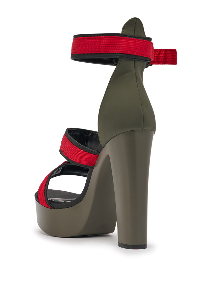 The AZALEA WANG RAYLYN RED PLATFORM CHUNKY SANDAL features thick red straps and an olive green faux leather base, with a chunky heel, shown from a rear side angle on a white background. 5