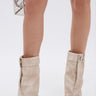 A person wears the AZALEA WANG REEVES NEW OPEN TOE PU BOOTIE IN BONE and carries a small silver wire handbag, with the photo highlighting their legs and accessories against a plain white background.