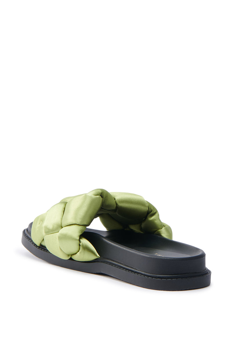 The AKIRA REIGNS Olive Braided Puff Slip-On Sandals feature green quilted straps with a satin textile upper and a black flat sole, elegantly displayed against a plain white background to showcase their side and back profiles.