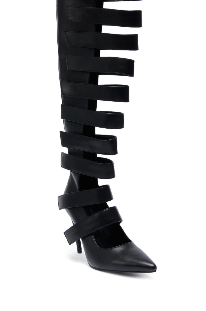 The AZALEA WANG REIN BLACK THIGH HIGH BOOT is crafted from faux leather with wide horizontal cutouts and straps, featuring a pointed toe and a short, thin heel.