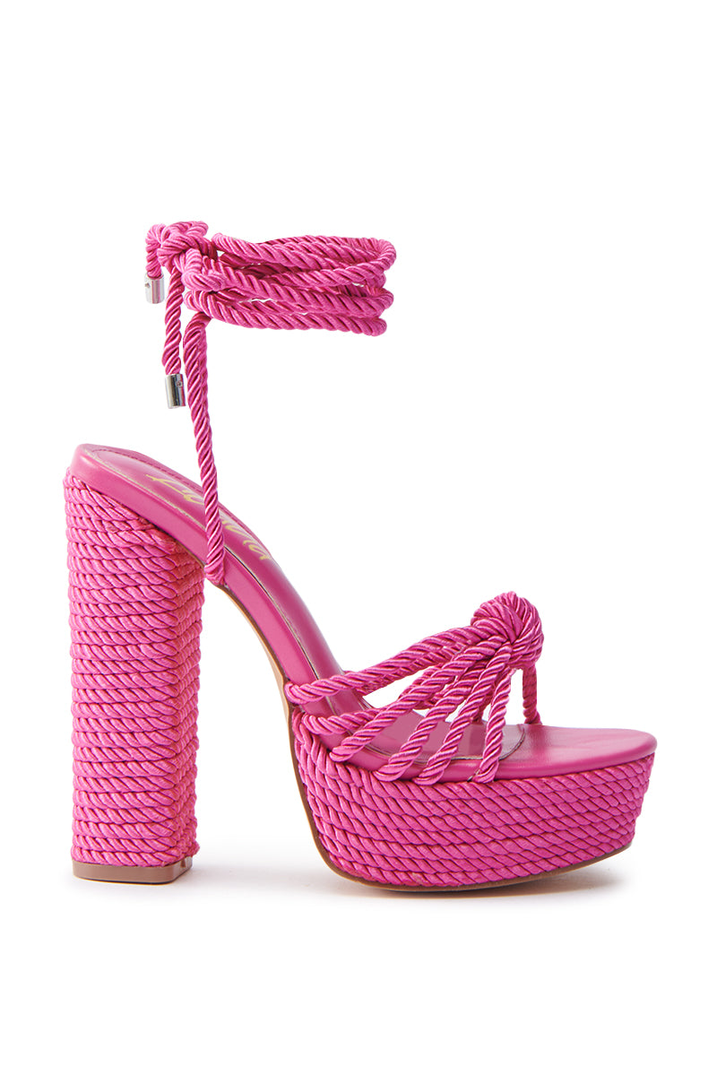 The RENEE FUCHSIA ROPE DETAIL LACE UP SANDAL features a rope design, thick sole, chunky block heel, and elegant laces around the ankle. It's crafted from vibrant pink material with a comfortable faux leather insole.