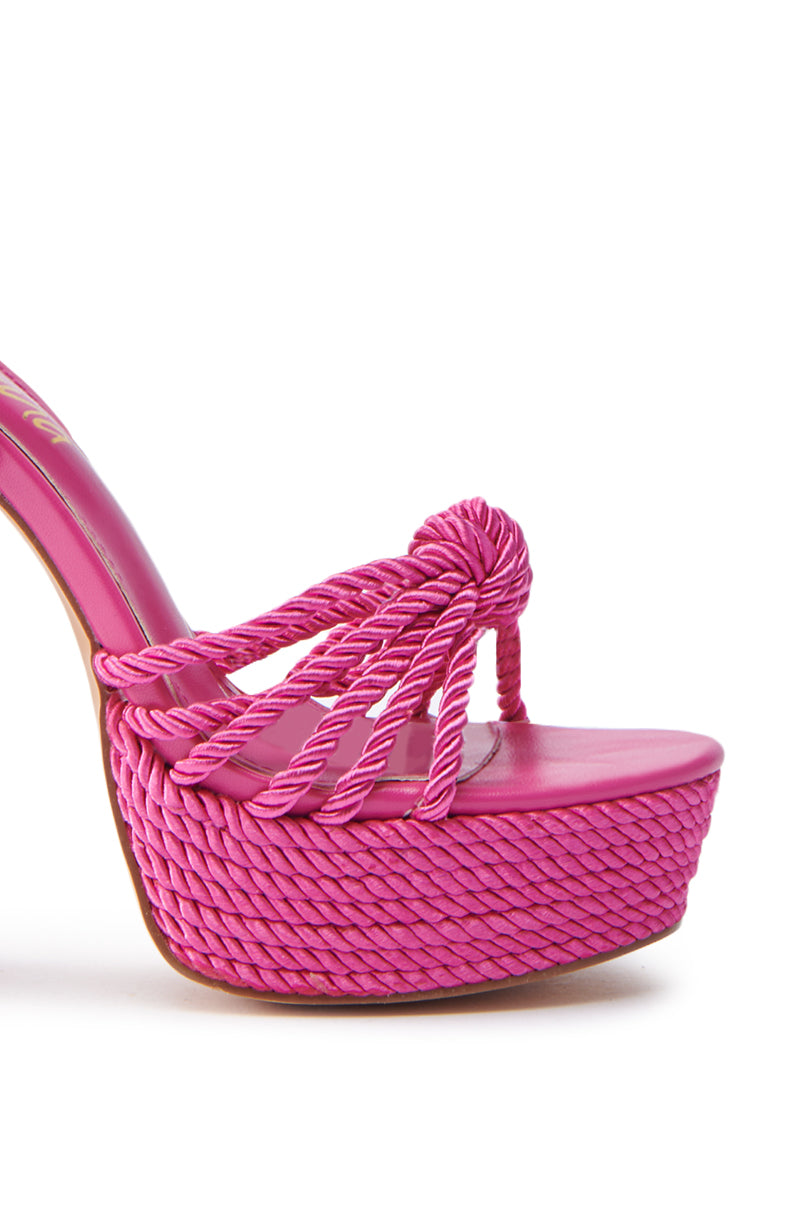 Close-up of the RENEE FUCHSIA ROPE DETAIL LACE UP SANDAL, a vibrant fuchsia platform with a chunky block heel. It features braided straps and a platform for texture, while the faux leather pink insole complements its vivid look.