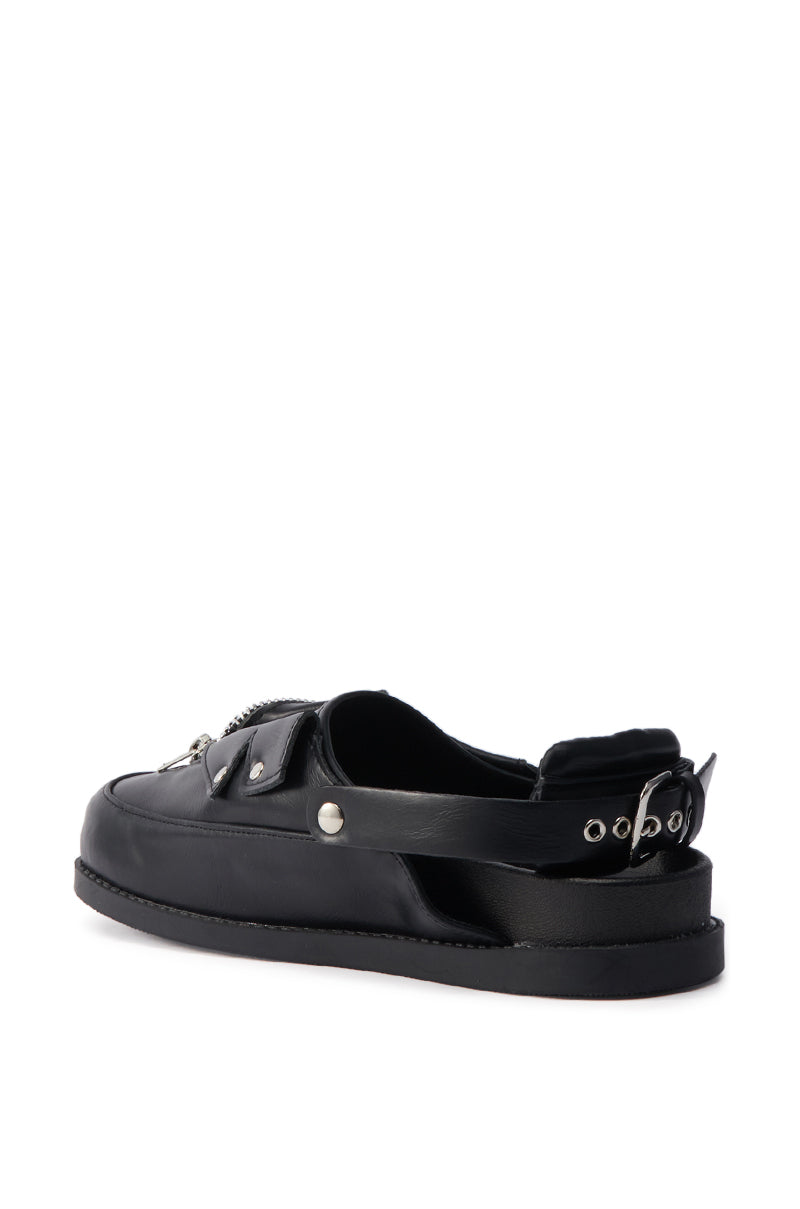 The AZALEA WANG RESTER BLACK HARDWARE EMBELLISHED MULE is a black faux leather slingback shoe featuring metallic zipper details, silver hardware, a thick flat sole, and an adjustable heel strap with eyelets and buckle, shown on a white background.