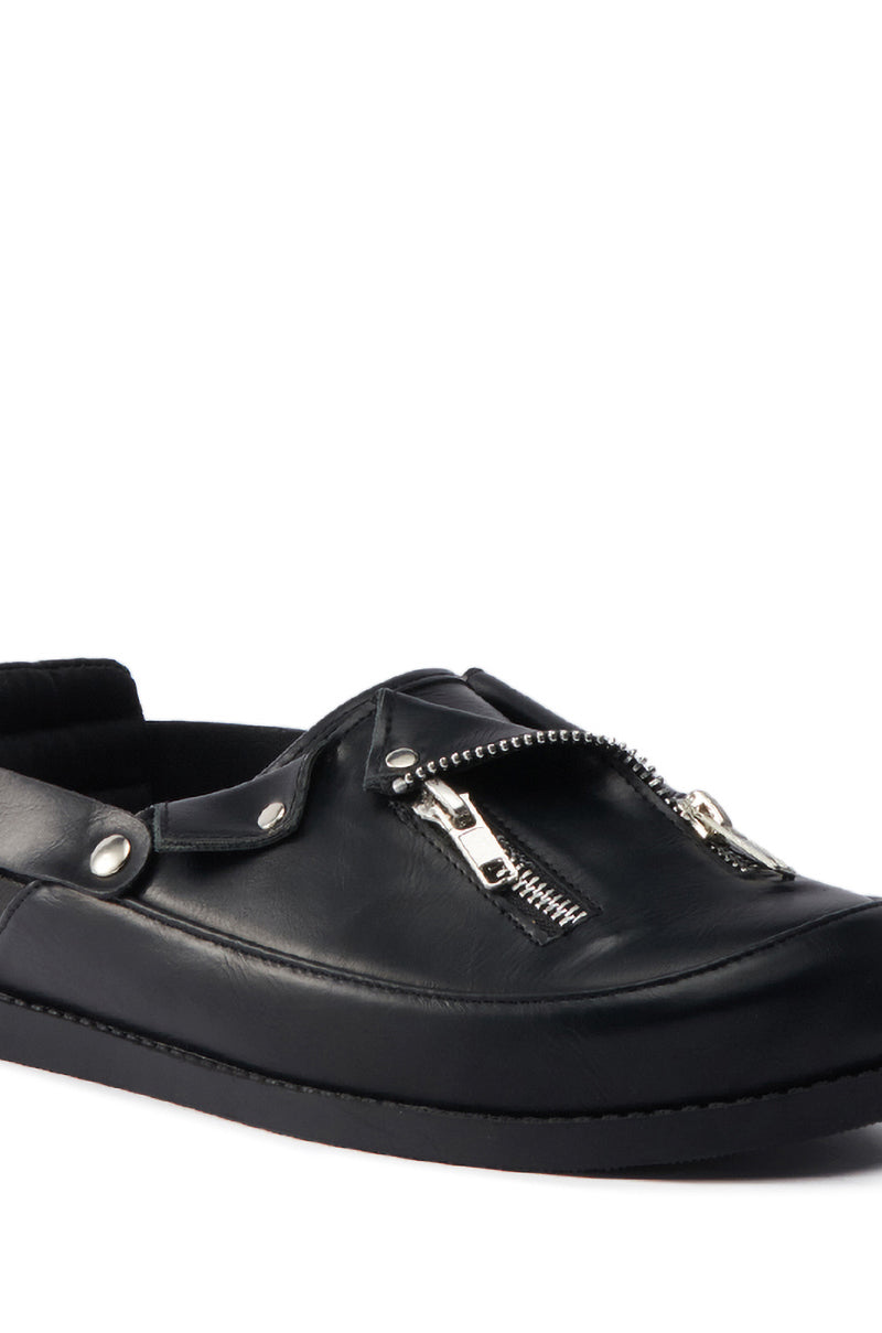 The AZALEA WANG RESTER BLACK HARDWARE EMBELLISHED MULE is a black faux leather slip-on with a flat sole, metallic zipper details, and metal studs on the upper for the perfect blend of edgy style and comfort.