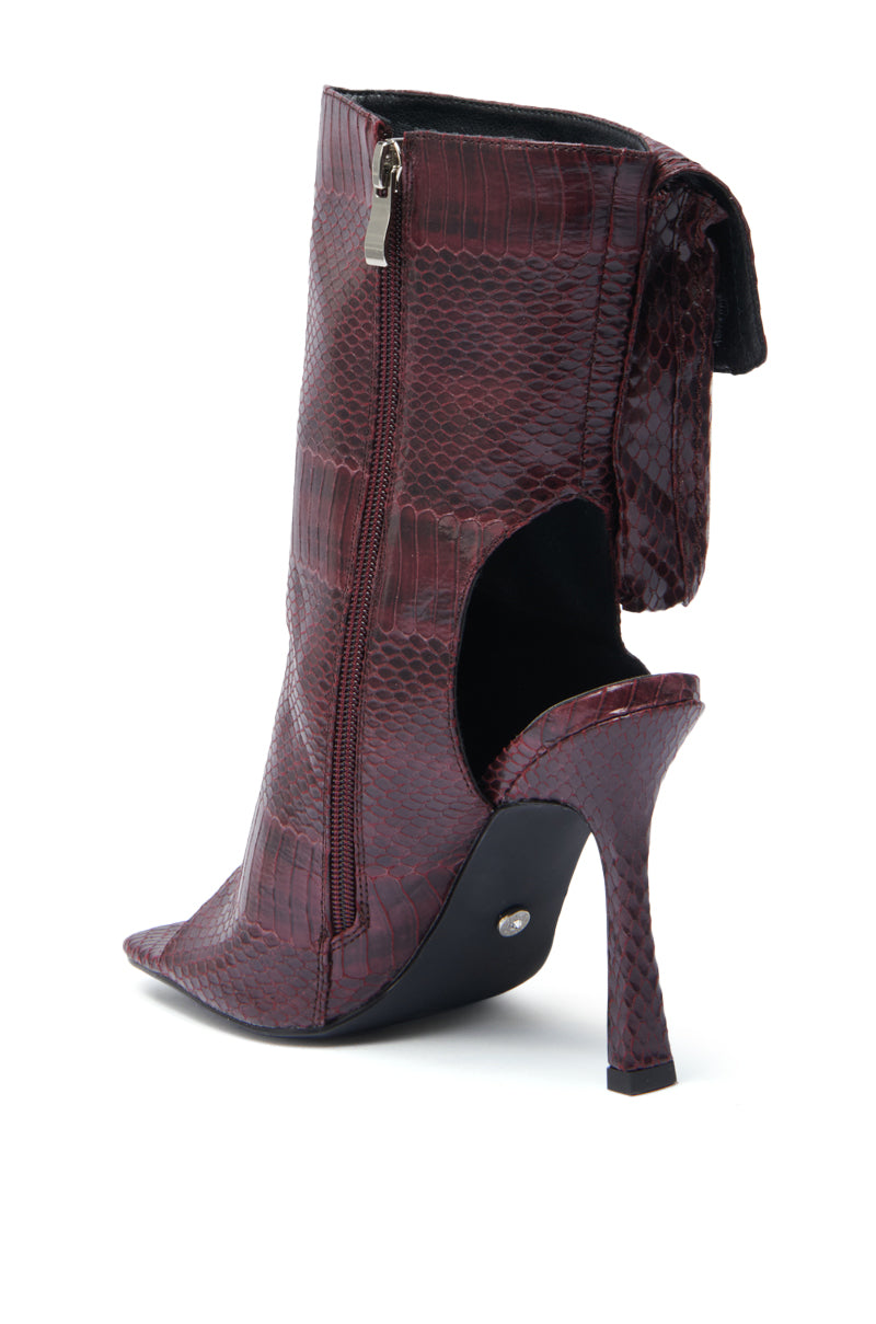 The AZALEA WANG RIDWAN BURGUNDY SNAKE OPEN TOE BOOTIE is a high-heeled faux leather bootie featuring a burgundy snake print, side zipper, open toe and heel, plus an edgy cutout ankle design.
