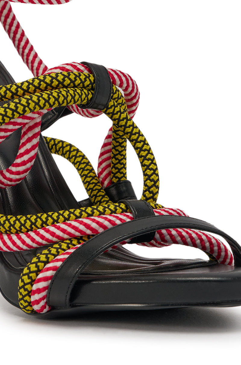 The AZALEA WANG RIJN ROPE STILETTO LACE UP SANDAL features a black leather sole, a multicolor wraparound heel, and intricately wrapped red-and-white striped and yellow-and-black patterned rope straps. 6