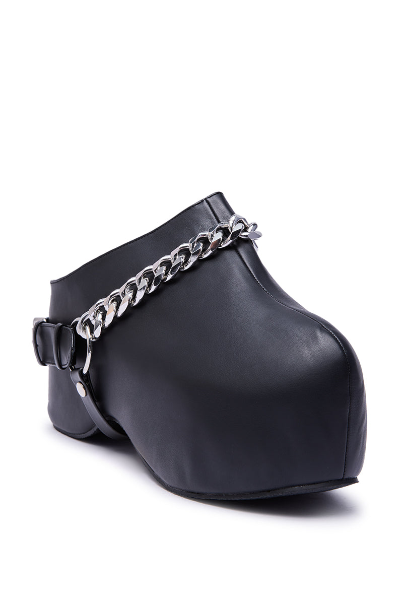 The AZALEA WANG RILLMEY BLACK FLAT CLOG features a bold, modern design with an exaggerated shape, chunky heel, and striking silver chain and buckle metal details across the top for an unconventional look.