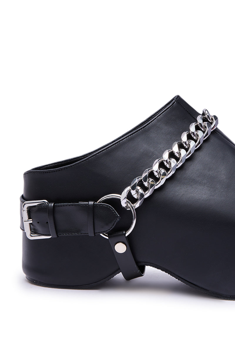 The AZALEA WANG RILLMEY BLACK FLAT CLOG WITH METAL DETAIL features black faux leather, a bold silver chain across the side, decorative metal buckle and strap details, smooth finish, and a modern chunky silhouette.