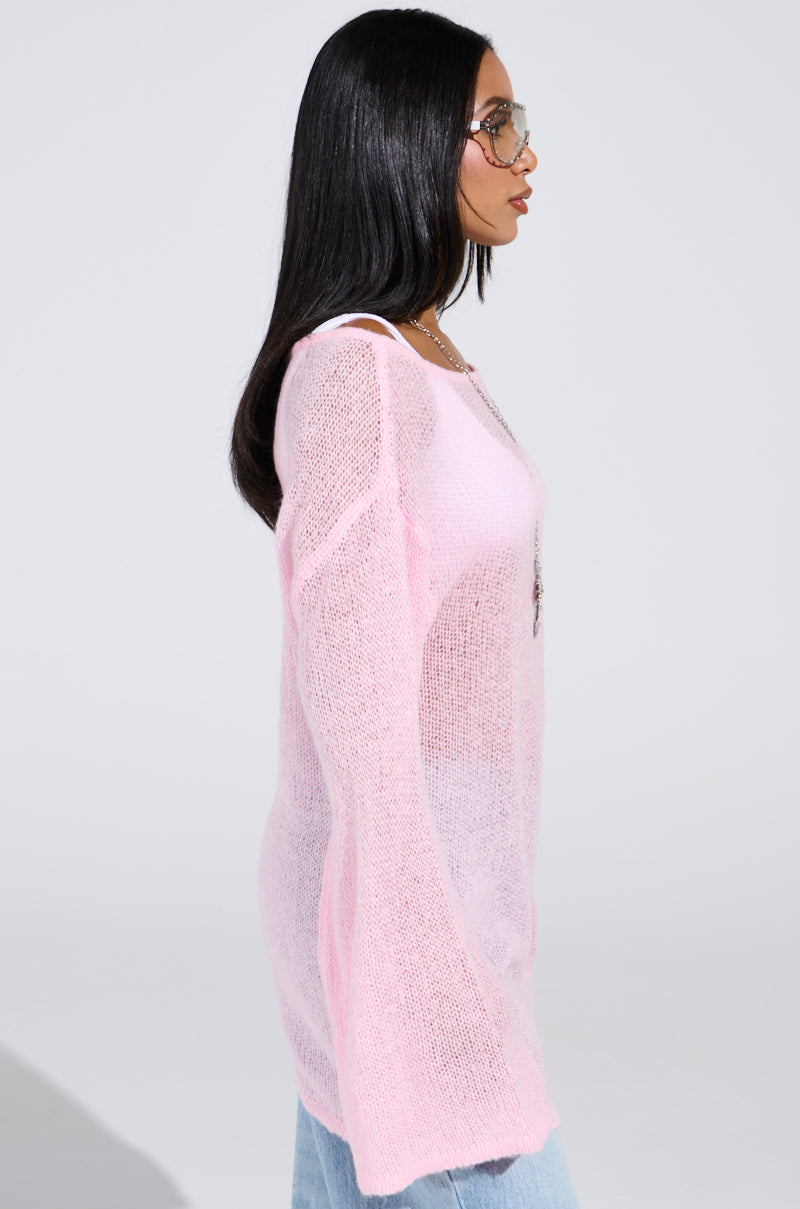 A person with long dark hair, wearing aviator sunglasses and the BE READY IN 5 SWEATER DRESS, is seen in profile against a plain background.