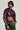 Dressed in a dark purple NATALIA CROCODILE PU BUTTON DOWN SHIRT, the individual pairs it stylishly with camouflage pants. Their hair is styled neatly, and they pose confidently against a plain background.