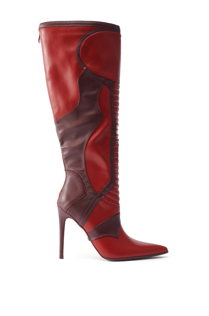 The AZALEA WANG RODRIGO RED BOOT STILETTO is a fashion-forward, knee-high stiletto in burgundy leather with patchwork details, a pointed toe, and textured panels, shown on a white background.