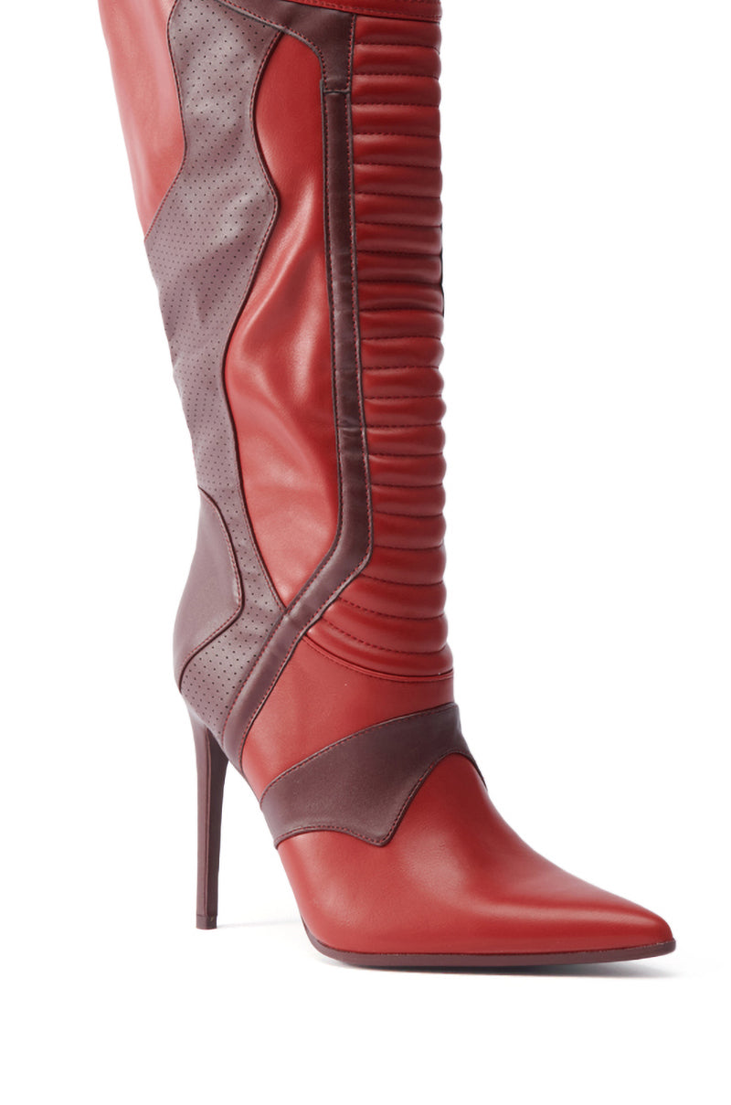 The AZALEA WANG RODRIGO RED BOOT STILETTO is a fashion-forward knee-high boot with a pointed toe, high stiletto heel, red and burgundy leather panels, ribbed front texture, and side perforated details.