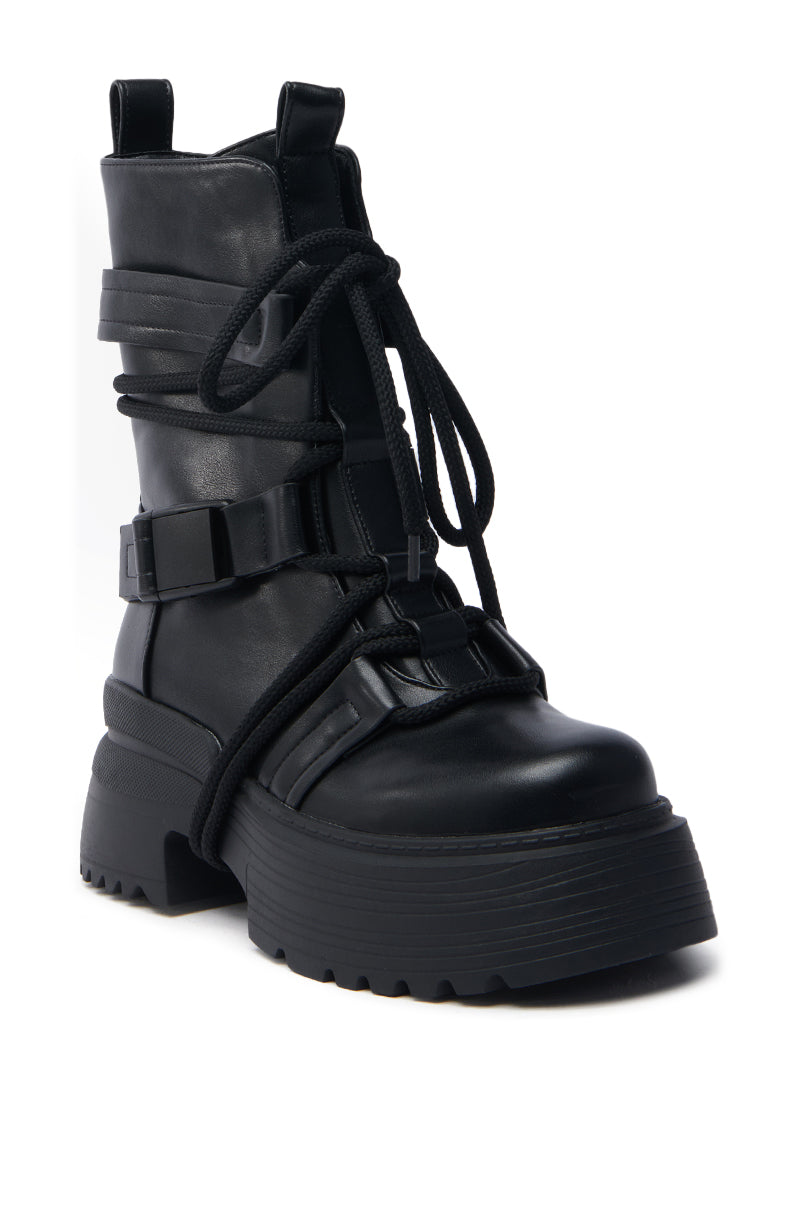 The AZALEA WANG ROISIN BLACK COMBAT BOOTIE features a chunky heel, multiple buckles, and long wrap-around laces for added detail. Crafted from vegan leather, this bootie combines a rugged and modern design with both functional and stylish elements.