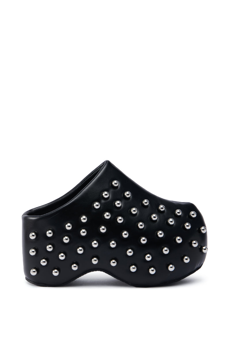 The AZALEA WANG ROMESCO BLACK EMBELLISHED CLOG is a bold and modern shoe with a unique sculpted shape, adorned with multiple rows of silver studs. Made from shiny faux leather, it features a thick, chunky platform sole that enhances its striking appearance.