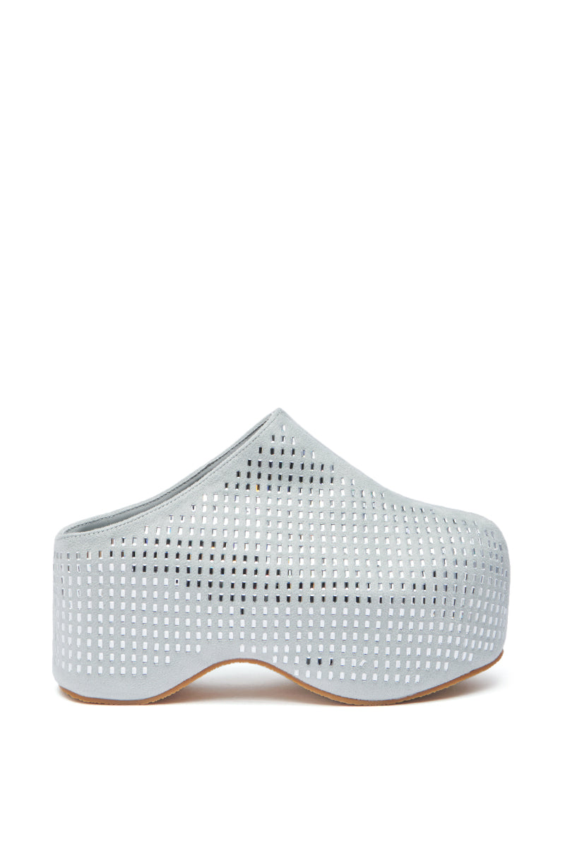 The AZALEA WANG ROMESCO BLING FLATFORM CLOG IN GREY is a single light grey faux suede slip-on with a perforated square pattern, rounded toe, and slightly curved sole, shown in profile against a white background.