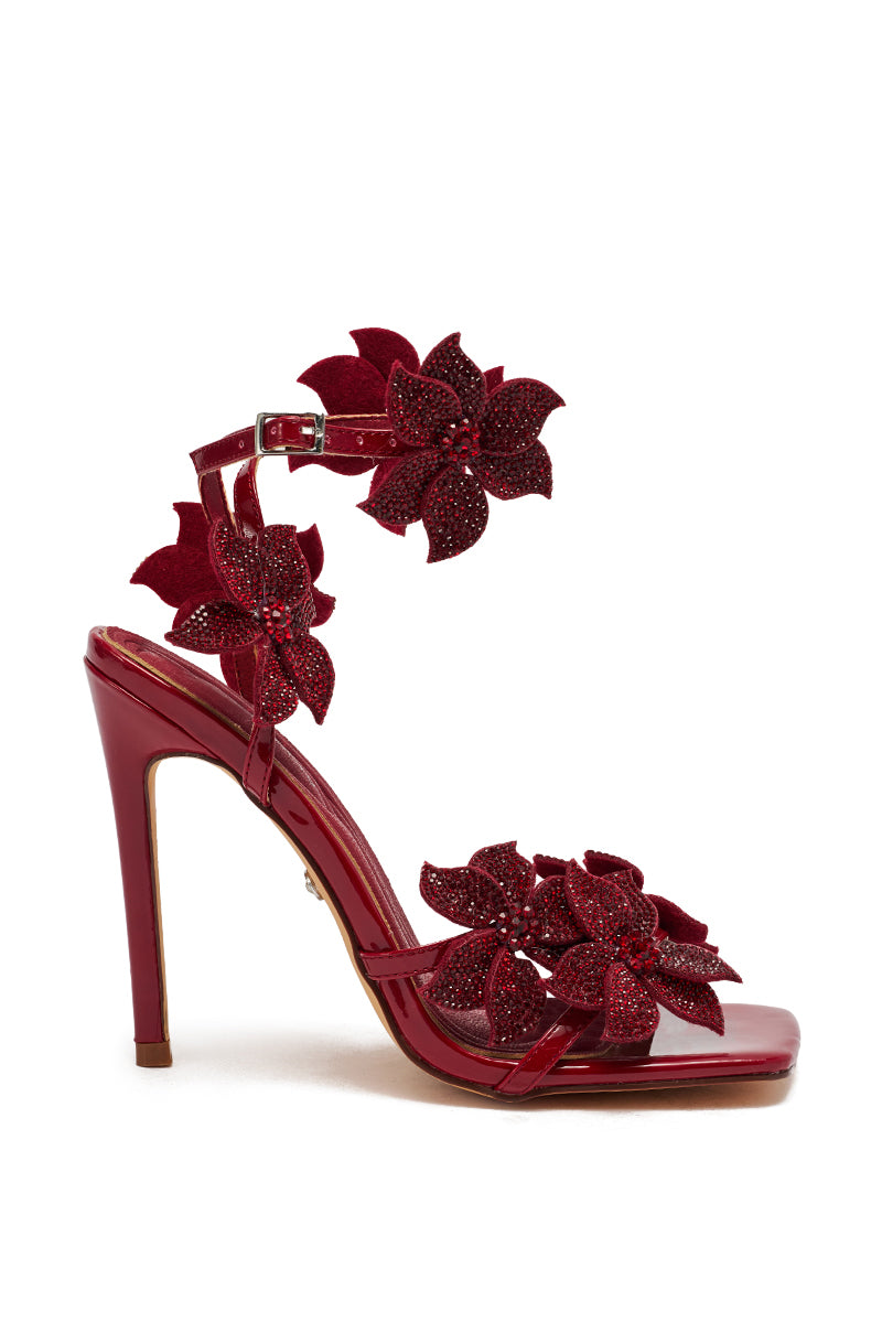 The AZALEA WANG ROMI DARK CHERRY RHINESTONE FLORAL EMBELLISHED SANDAL features a glossy faux leather finish, sparkling rhinestone flowers on the ankle and front straps, and a chic stiletto heel.