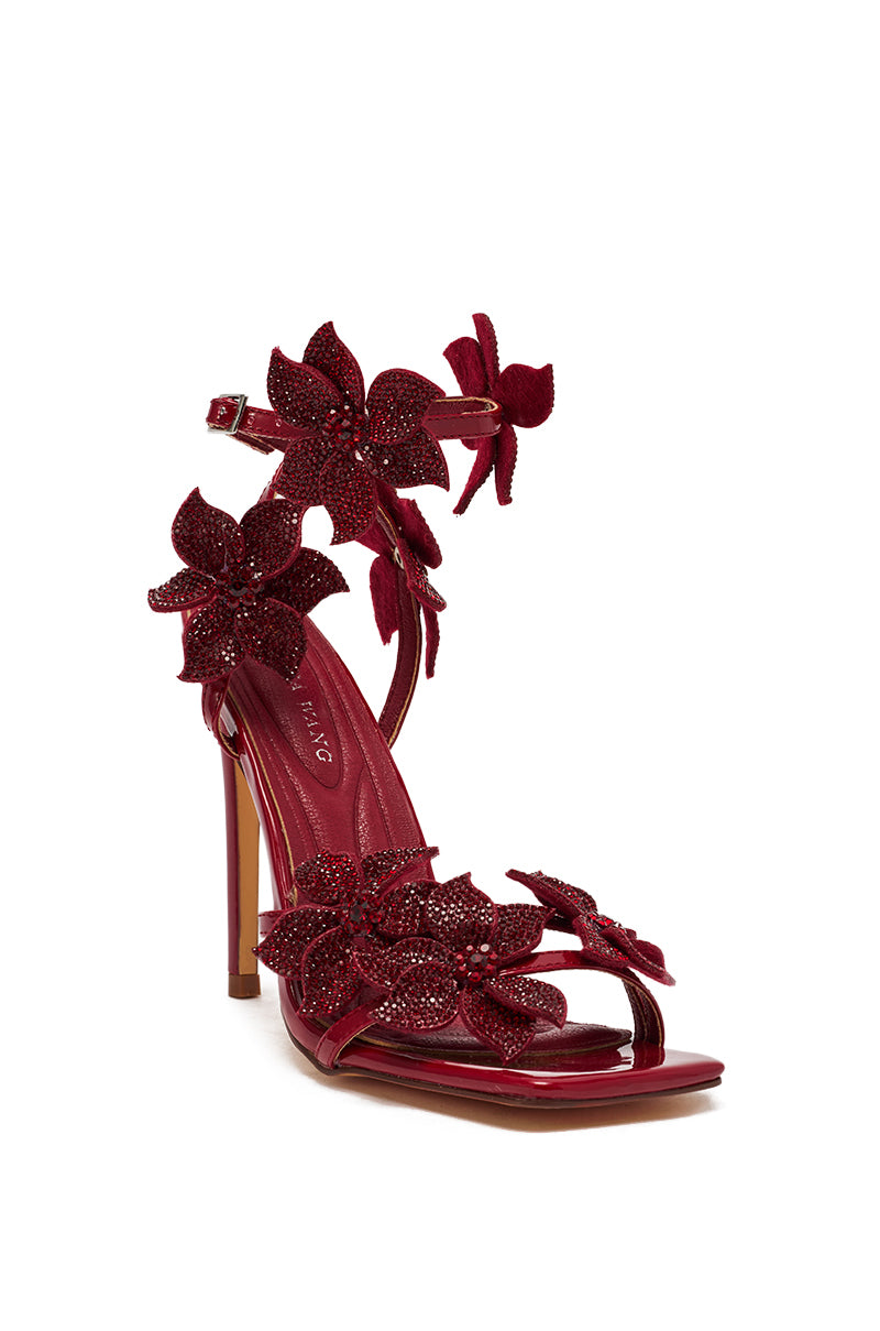 The AZALEA WANG ROMI DARK CHERRY RHINESTONE FLORAL EMBELLISHED SANDAL features a red faux patent leather stiletto heel, ankle strap, open toe, and sparkling floral details for an elegant, modern look.