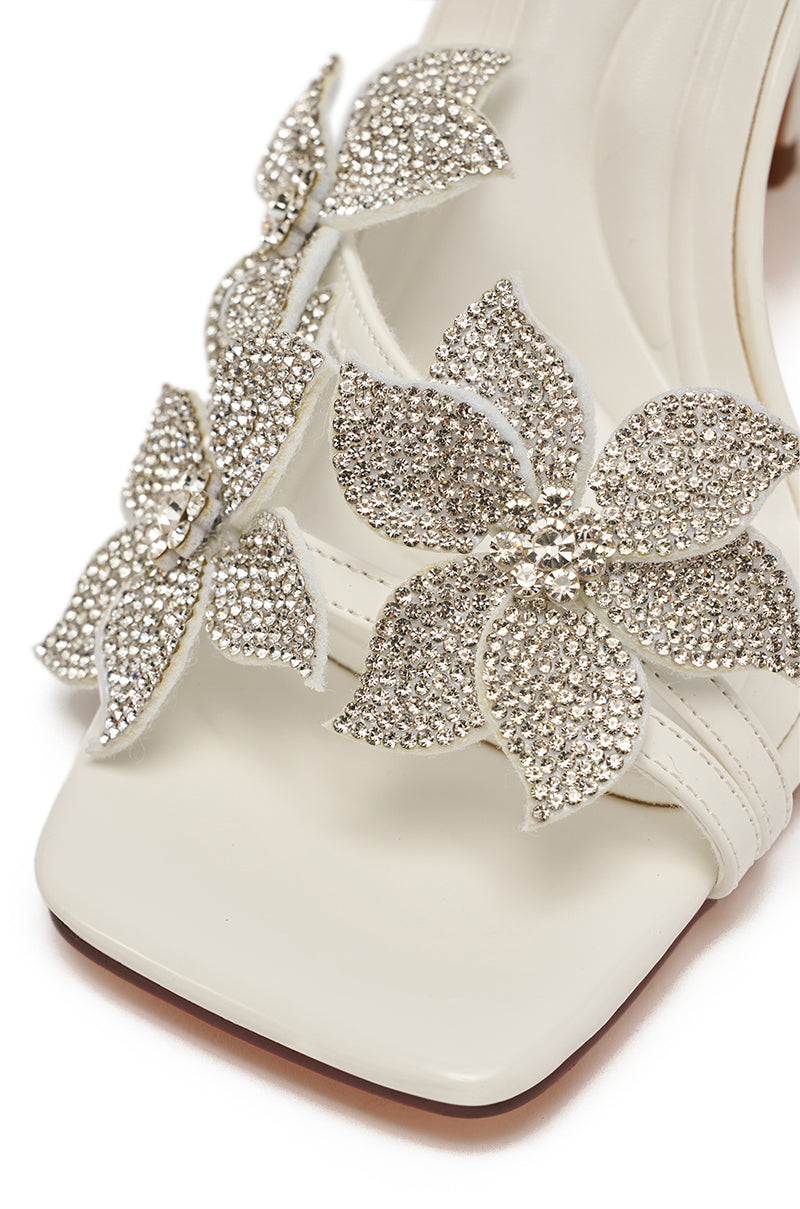 The AZALEA WANG ROMI White Floral with Rhinestones Stiletto Sandal features a faux patent leather upper, square toe, and three sparkling floral rhinestone embellishments.